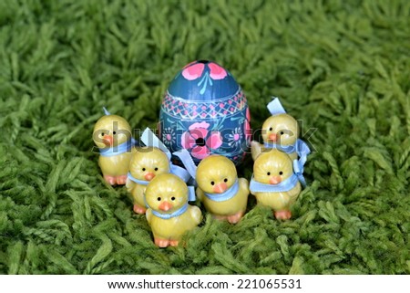 Six ceramic Easter chickens guarding painted Easter egg