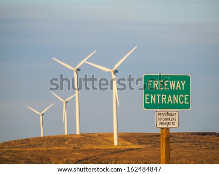 Windmill Farm on a Mountain with Freeway Entrance Signs at Dusk
