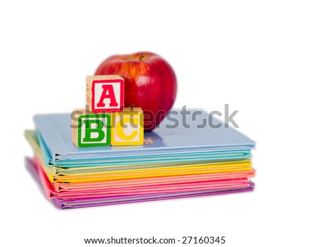 ABC Blocks and a Red Apple arranged on a stack of rainbow colored children\'s books.  Isolated on white.