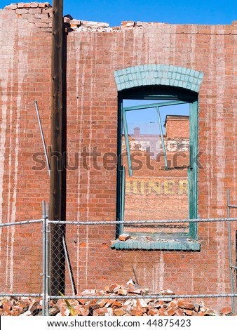 Brick wall and broken window at a demolition site