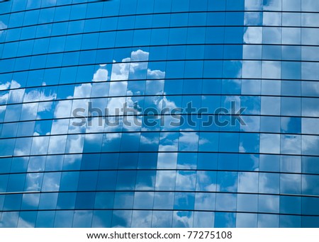 Clouds reflected in windows of modern office building