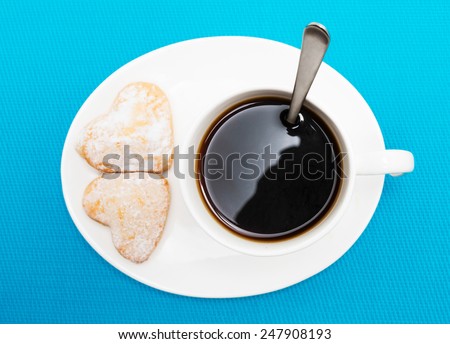 Coffee with spoon inside and cookies, top view