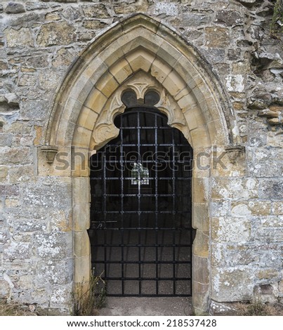 Stone door or window with bars in England.