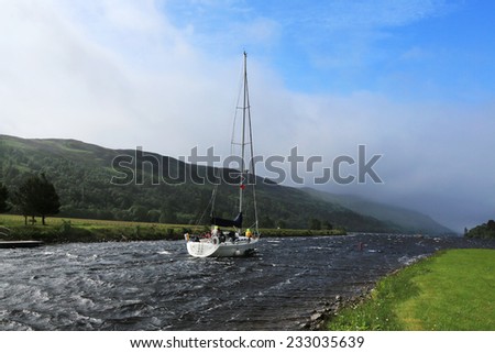 Sailboat floats channel in windy weather, Scotland