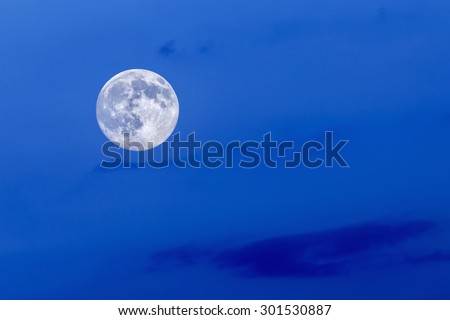 Full blue moon at blue sky background.