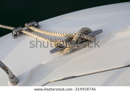 Close-up nautical knot rope tied around stake on boat or ship, boat mooring rope.