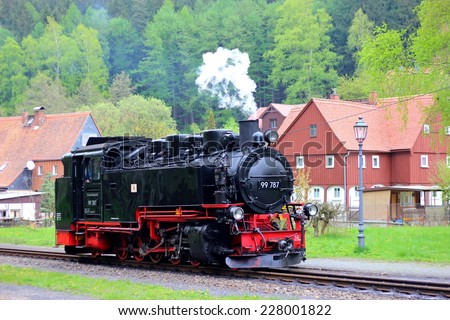OYBIN, GERMANY- APRIL 27, 2014: Steam engine train - tourist steam train with black smoke running on the highway from Zittau to Oybin in the mountains, Germany