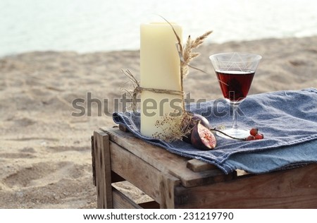 candles and red wine - romantic dinner on the water in Scandinavian style/Candle and red wine on the beach