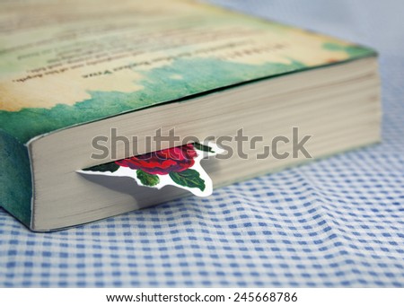 Bookmark in book on blue white checkered table cloth