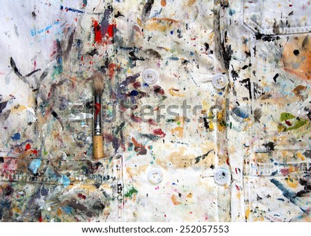 White lab coat covered in paint colors and one paintbrush; horizontal composition