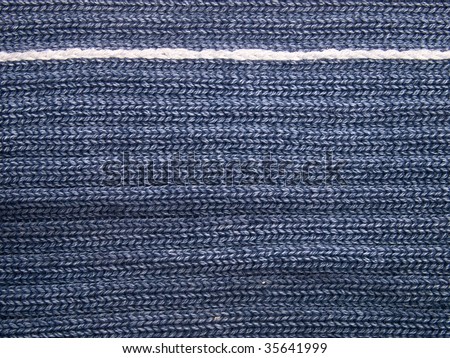 Macro looking to a knitted fabric with white stitch