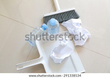 A close up shot of household floor cleaning items and paper ,bottle