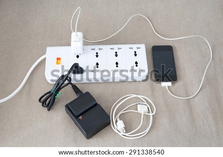 Power cord with several adapters and chargers for various electronic devices in a paperless office