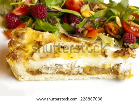 Tart with goat cheese and salad with raspberry, lettuce and tomatoes