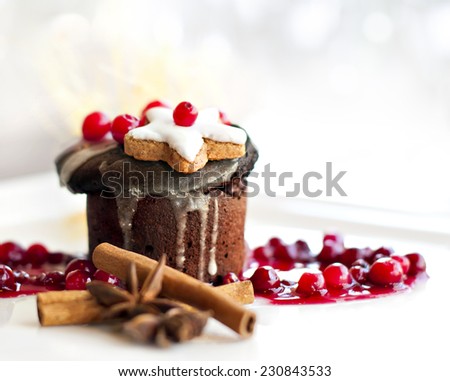 Molten lava cake dessert or dark chocolate souffle served with gingerbread, berries cinnamon sticks, anise on white plate