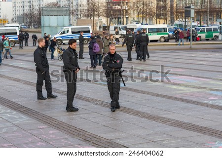 Leipzig, Germany - January 21: Group of police officers reading text on ground. Students were drawing \'Anti-Pegida\' symbols all over the August Platz ground on January 21, 2015 in Leipzig, Germany