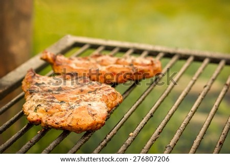 Stock photo of a 2 steaks on BBQ. Golden tinted. Focus on the front of the foreground steak. Image with little bit of corner darkening