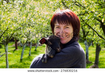 Middle aged lady with a lamb portrait. Organic/Bio farming concept