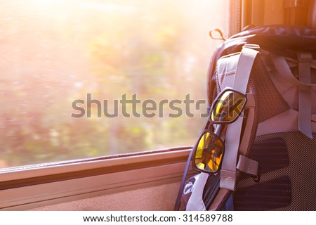 Backpack with glasses on seat in moving train. Stock image for traveling concept