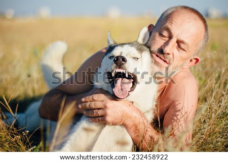 Old man plays with his dog Siberian Husky. Lifestyle. Active recreation. Photo toned style Instagram filters.