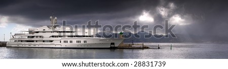A yacht boat in a safe harbor with a storm approaching in the sky