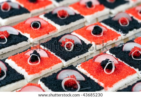 a plate full of Red and Black Caviar Canapes with radish and green onions rings