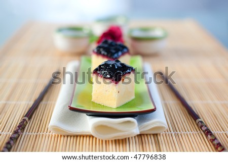 Japanese cheesecake treats served on an asian plate with chop sticks. Shallow depth of field on the first cheesecake treat.