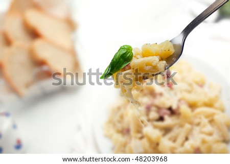 Pasta with Potatoes Provola Cheese and Bacon on a white table
