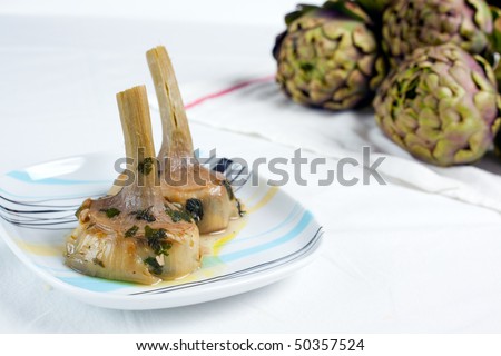 a plate with a couple of artichokes hearts cooked \
