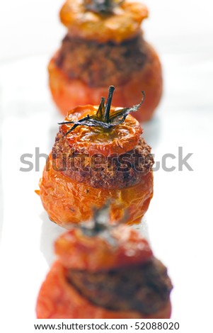 Baked stuffed tomatoes with veal minced meat, eggs, cheese, basil, black pepper, onion, garlic, mortadella. Macro shot: shallow depth of field on one tomato