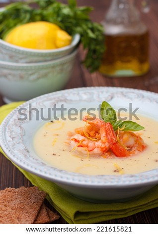 puree soup with vegetables - cauliflower, potatoes and onions with red lentils and shrimp in a blue plate