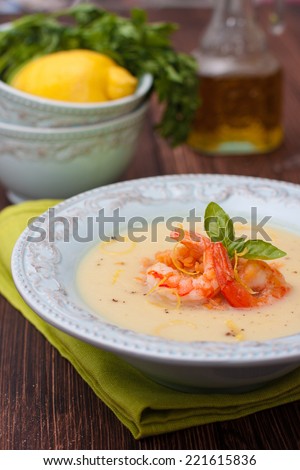 puree soup with vegetables - cauliflower, potatoes and onions with red lentils and shrimp in a blue plate