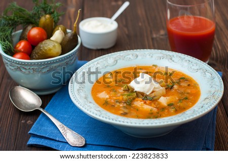 soup with pickled cucumbers, potatoes, carrots, tomato and sour cream. pickle. Russian cuisine.