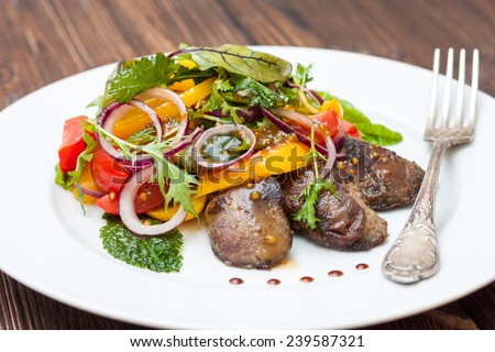 Warm salad with chicken liver, sweet peppers, cherry tomatoes and salad mix