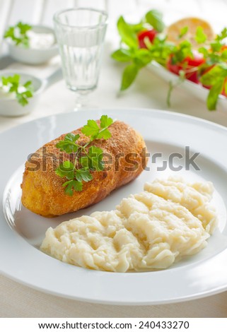 chicken Kiev with mashed potatoes.Ã?Â  Chop chicken fillet stuffed with juicy butter, cheese and greens on a white plate