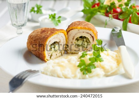 chicken and chicken Kiev with mashed potatoes.  Chop chicken fillet stuffed with juicy butter, cheese and greens on a white plate