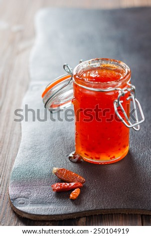 marmalade hot pepper in a jar on a background of dark skin