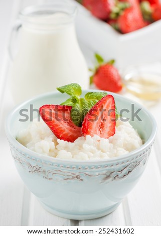 rice milk porridge with strawberries and mint on a white background
