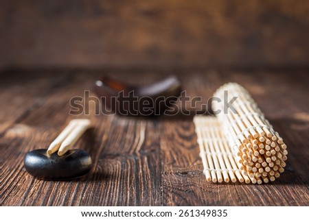 mat for sushi and chopsticks on dark wooden background. Copy space