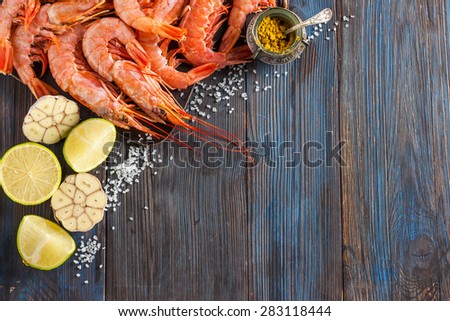 raw shrimp, garlic, lime, curry and sea salt on a dark wooden background. Copy-space