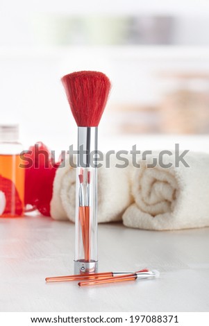 Red makeup brush set placed on a makeup table.