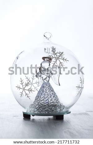 Christmas glass ball with angel inside on white background.
