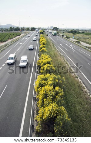 General view of a highway with cars and truck traffic