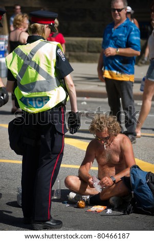 OTTAWA, CANADA - JULY 1: A female Police Officer confronts an unidentified, shirtless man on Wellington street during the July 1st, 2011 Canada Day celebrations in Ottawa, Ontario Canada.