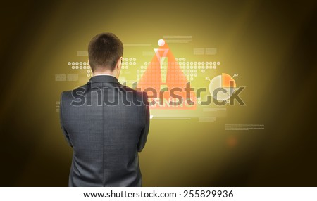 Man in suit is standing back and watching on colorful graphics on yellow blackground