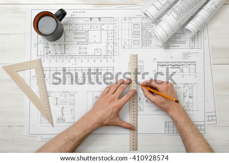 Close-up hands of architect while working process with centimeter ruler