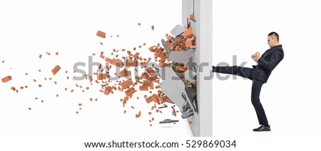 Businessman kicking hard the wall and crush it, side view. Overcoming obstacles. Business issues. Economic development.