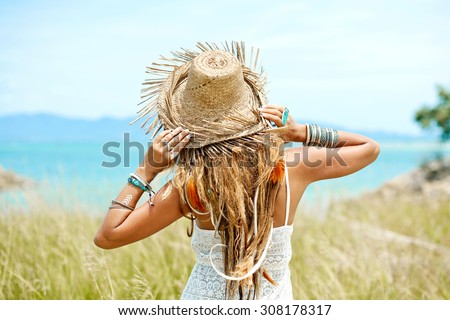 Summer girl in straw hat on the field. Back view