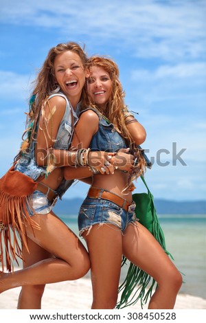 Two smiling girls friends on the beach