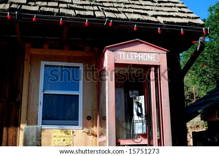 Old Telephone booth with red Christmas lights above on building